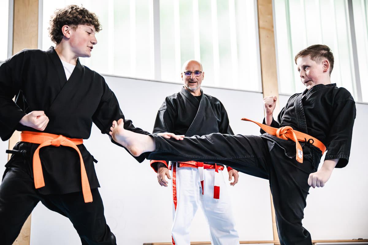 Taiwan-Do-Training in der Halle: Trainer zeigt einen hohen Tritt
